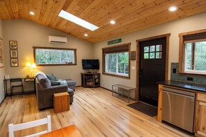 A cozy interior with a sofa, TV, and a small kitchen area. - Private Evergreen Hideaway (Sequim)