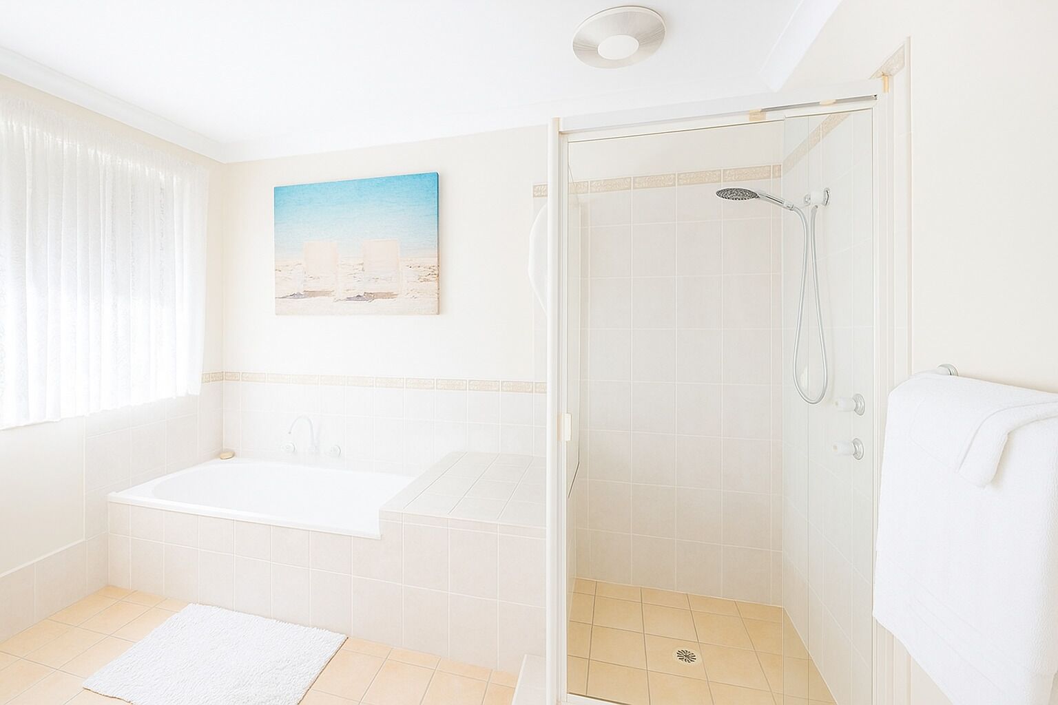 A bathroom with a bathtub, shower, and a window with curtains.