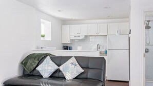 A modern kitchen with white cabinets, a built-in oven, and a refrigerator. - Bonfire Studio • King Bed • Pet Friendl (Lakeland)
