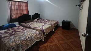 Quarto com duas camas, ar condicionado, televisão e carpete estampado.