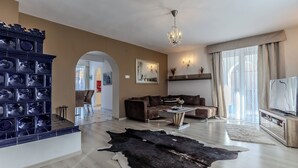 Ein modernes Wohnzimmer mit Kamin, einer Couch, einem Couchtisch und einem Fernseher.