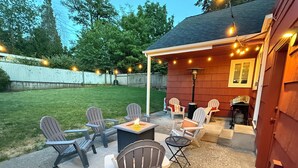 An outdoor patio with Adirondack chairs, a fire pit, and string lights. - TrackTown Retreat-Walk to Hayward Field & U of O (Eugene)