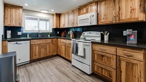 A kitchen with wooden cabinets, a microwave, an oven, and a dishwasher. - TrackTown Retreat-Walk to Hayward Field & U of O (Eugene)