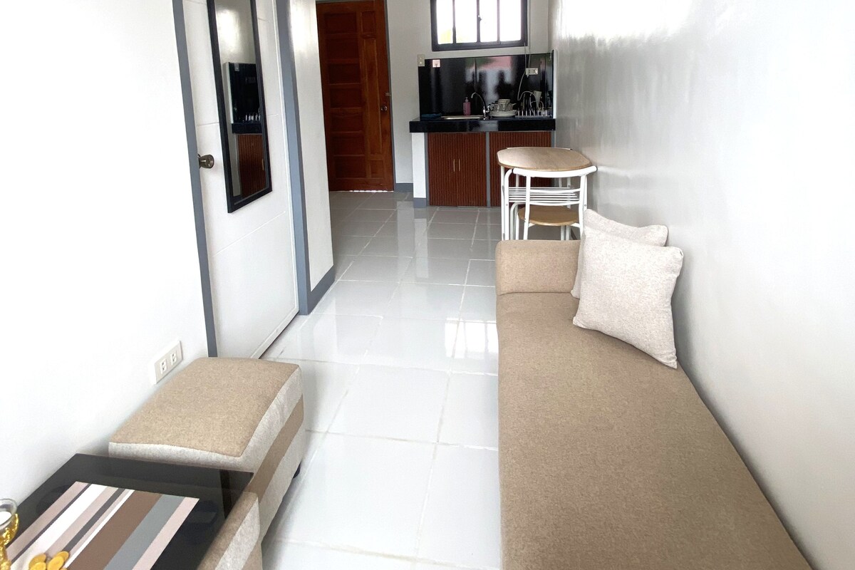 A modern living room with a sofa, a small table, and a staircase leading to another room.
