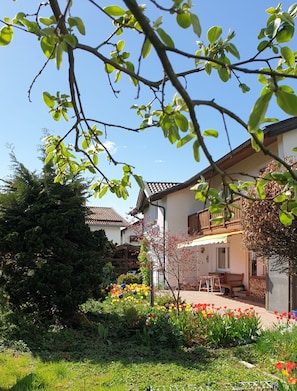 A residential building with a garden, outdoor seating, and a balcony. - Apartment 50sqm, with balcony (Seebruck)