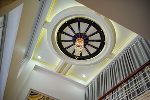 A grand, circular ceiling with a chandelier and a central decorative element.