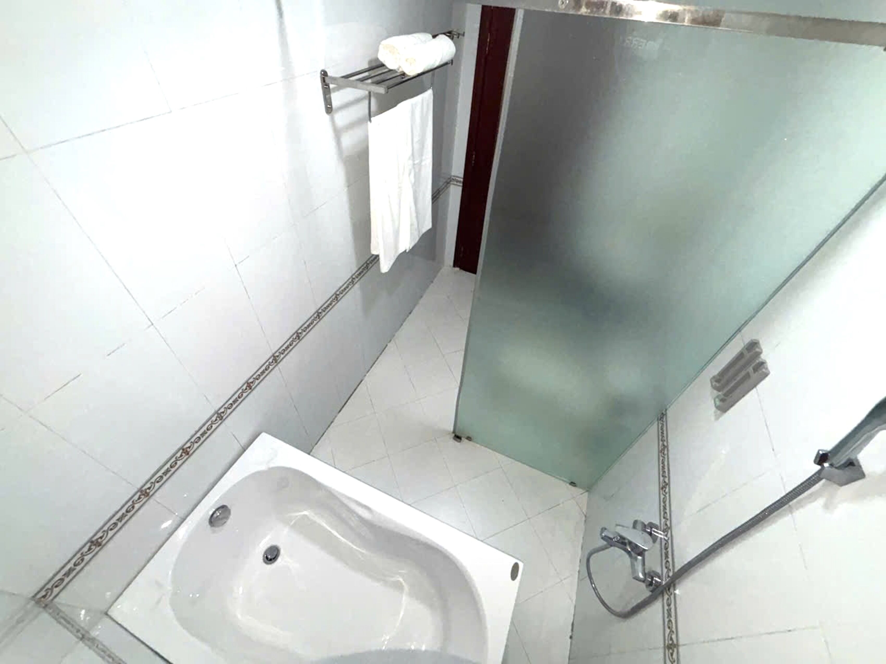 Un bagno con una vasca, un portasciugamani e una zona doccia.
