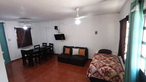 A room with a dining table, a sofa, a bed, a ceiling fan, and a TV mounted on the wall. -  Casa Villegas B céntrica en Linares - WiFi 100MB y asador (Linares)