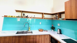 Une cuisine équipée d’un évier, d’un plan de travail et de meubles de rangement en bois.