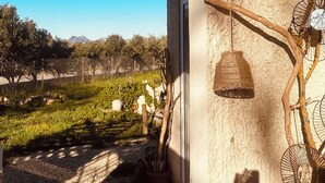 An arched doorway leading to a garden with a view of distant mountains, a hanging basket, and a rustic wall. - 2-bedrooms entire villa with jacuzzi and garden in charming Provence (Sénas)