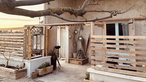 A rustic house with a wooden pergola, a small garden area, and a visible window. - 2-bedrooms entire villa with jacuzzi and garden in charming Provence (Sénas)