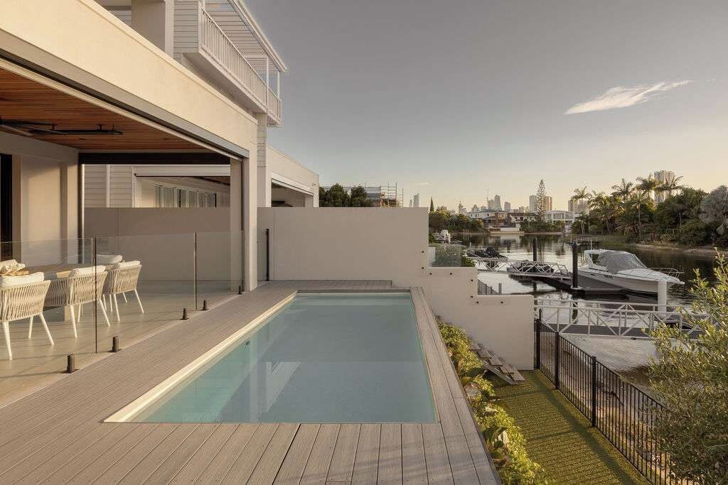 Ein moderner Poolbereich im Freien mit Blick auf einen Yachthafen und eine Skyline.