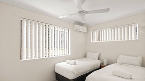 Camera da letto con due letti, una ventola a soffitto e un condizionatore d'aria.