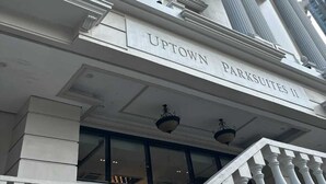 A building with classical architecture, including columns and a sign reading 'UPTOWN PARKSUITES II.'