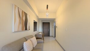 A hallway with a sofa, a dining table, and a door.