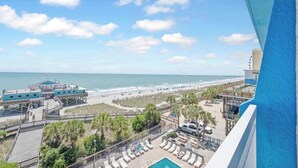 A beachfront hotel with a pool, beach access, and a view of the ocean. - Amazing Large Private Studio Condo with Amazing View (Myrtle Beach)
