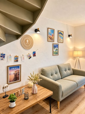 Un salon moderne avec un canapé, une table basse en bois et un escalier.