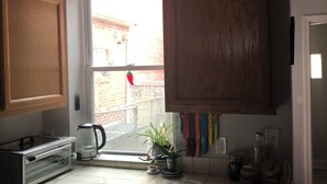 Une cuisine avec des meubles de rangement en bois, un grille-pain, une machine à café et un lave-vaisselle.
