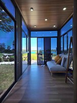 Un interior moderno con ventanas amplias, un sofá y una mesa.