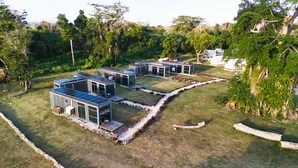 A modern eco-friendly residential complex with solar panels, multiple houses, and a lush green environment. - Nawesa Resort (Rentapow)