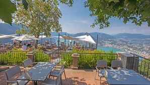 An outdoor terrace with tables and chairs, overlooking a city and mountains. - La Ca Da Bre - Garden House With Views (Lugano)