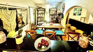 A dining area with a table, chairs, and a bowl of fruit.