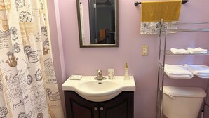 Une salle de bain équipée d’un lavabo, d’un miroir, de toilettes et d’un porte-serviettes.
