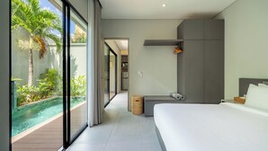 Een moderne hotelkamer met een groot bed, een klein bureau, uitzicht op een zwembad en een schuifdeur naar een balkon.
