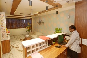 A reception area with a desk, computer, and seating.