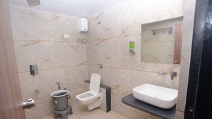 Une salle de bain équipée de toilettes, d’un bidet, d’un lavabo et d’un miroir.