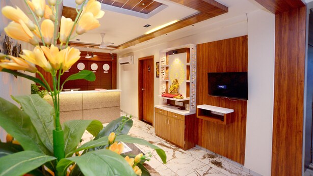 Un salon moderne avec un meuble en bois, un téléviseur à écran plat et un comptoir d’accueil.