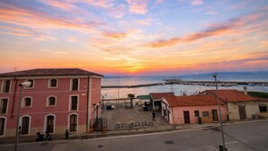 A coastal town with a pink building, a paved square, and a marina. - Cristallo Bilo 1 al Cavo (Rio Marina)
