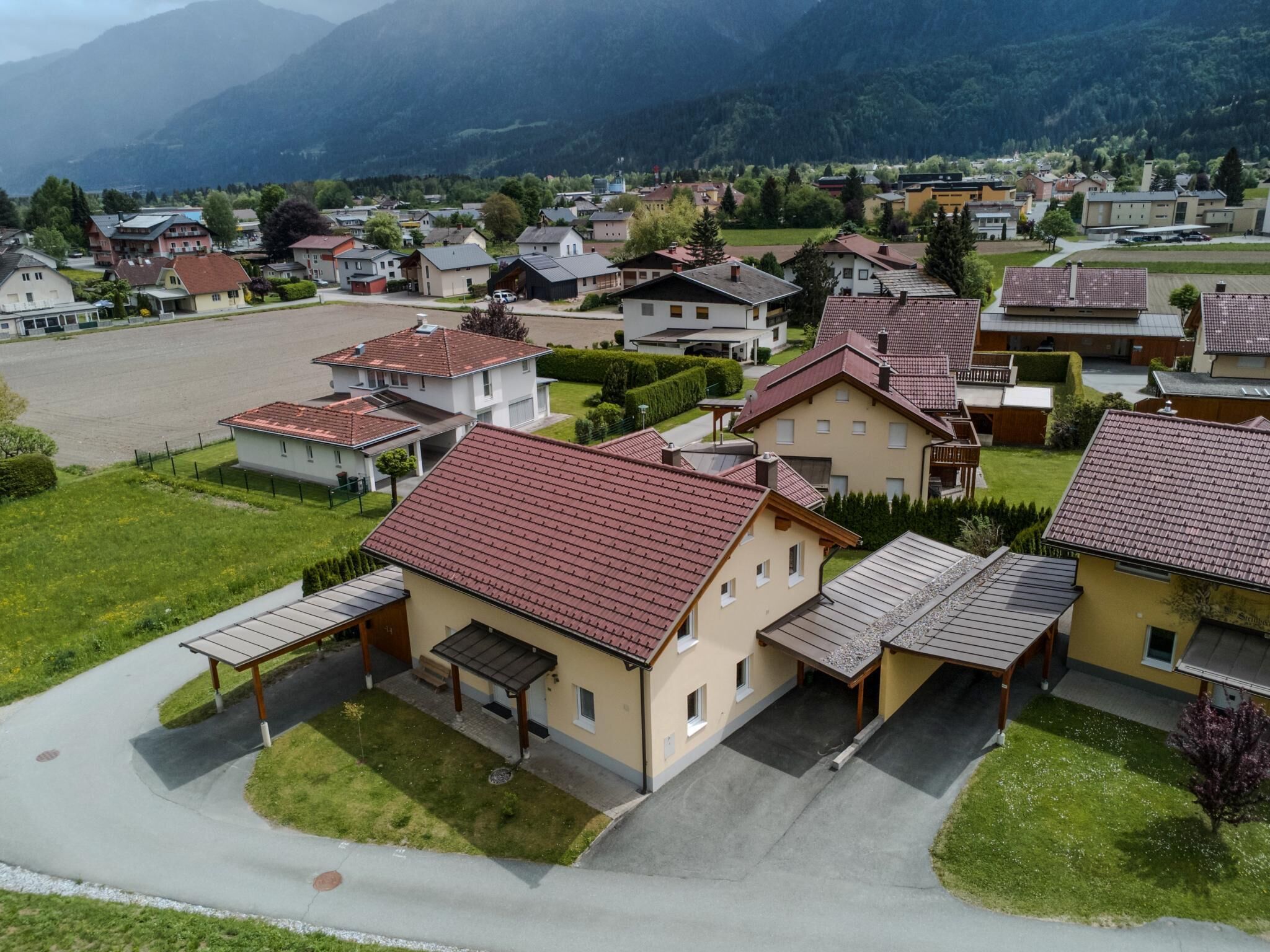 Un quartier résidentiel avec des maisons, une allée pavée et une chaîne de montagnes en arrière-plan.