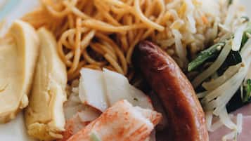 A plate with noodles, sausage, and various vegetables.