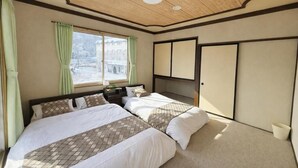 A bedroom with two beds, a window with curtains, a wardrobe, and a ceiling with recessed lighting. - START HOUSE PIAA-Ski IN Ski OUT (Minamiuonuma)