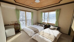 A bedroom with two beds, a desk, and a small refrigerator. - START HOUSE PIAA-Ski IN Ski OUT (Minamiuonuma)