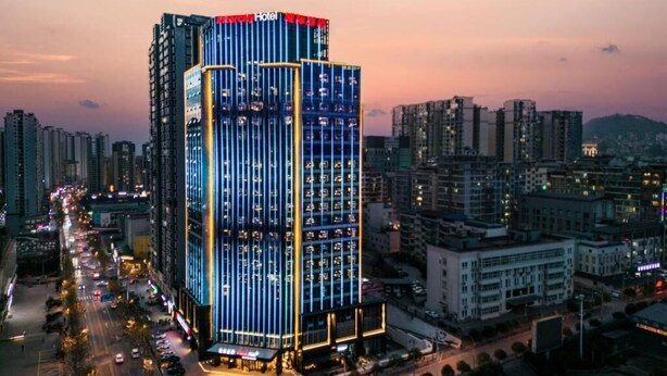 Un hotel de gran altura con un llamativo letrero que dice 'Hotel', varios pisos y un diseño arquitectónico moderno.