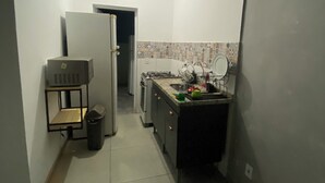 A narrow hallway with a kitchen area featuring a sink, countertop, and tiled backsplash. - Apartment 65m2 - comfortable, stylish, pet friendly, easy access to shops. (São Paulo)