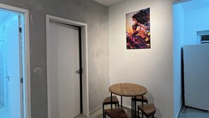 A room with a dining table and chairs, a door, a wall-mounted painting, and a ceiling light. - Apartment 65m2 - comfortable, stylish, pet friendly, easy access to shops. (São Paulo)
