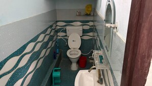 Une petite salle de bain avec des toilettes, un lavabo et un miroir.