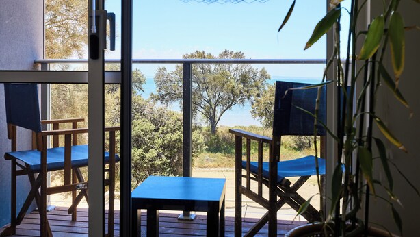 A balcony with a table and chairs, a potted plant, and a view of the sea. - Water’s Edge: 4BR all-ensuite. Sweeping estuary views for families and groups. (Falcon)