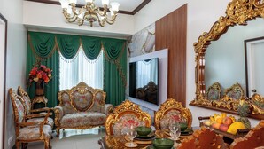 Ein luxuriöses Wohnzimmer mit aufwendigen Möbeln, einem Chandelier und einem großen Spiegel.