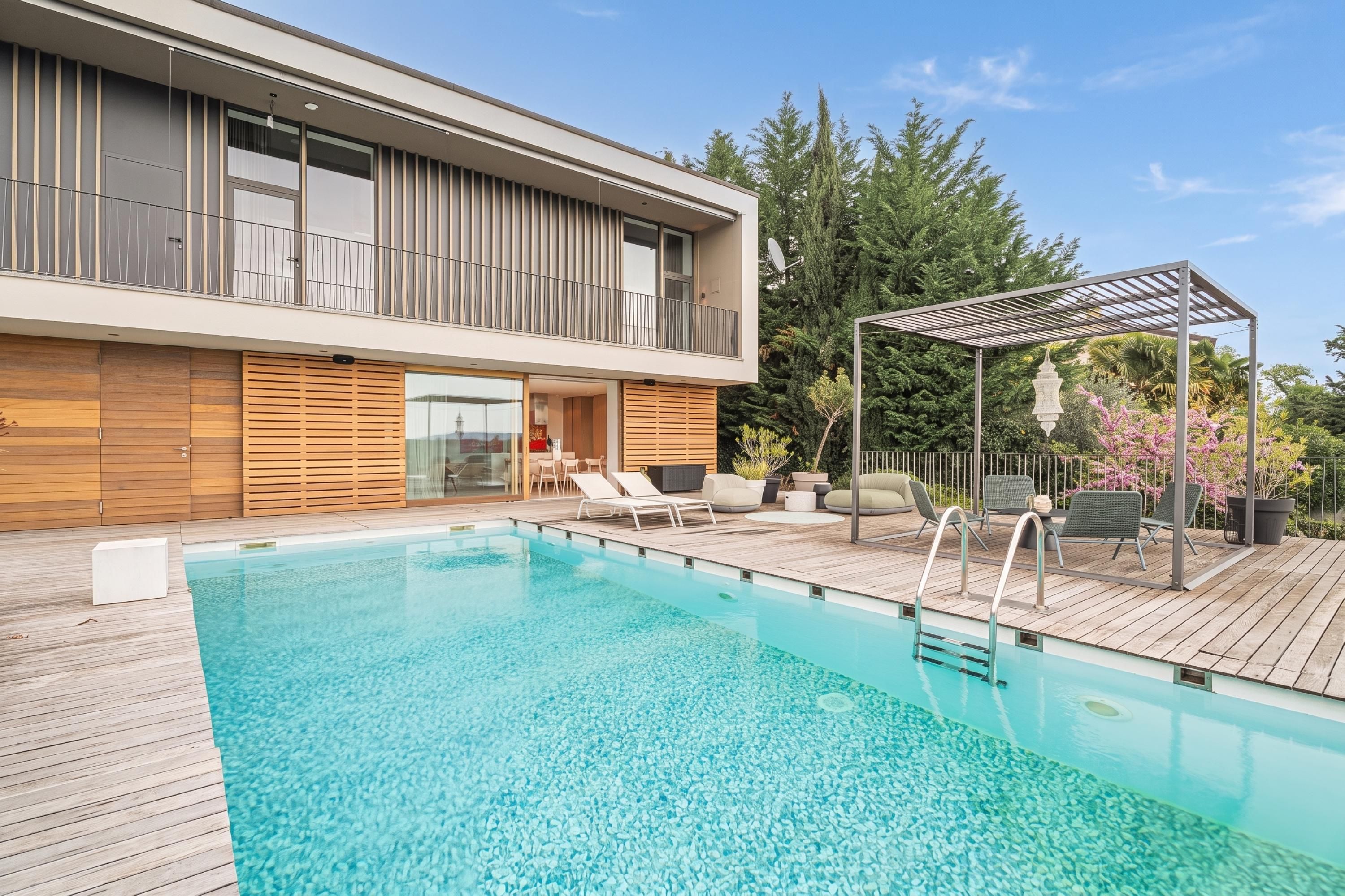 Une maison moderne dotée d’une piscine, d’un espace salon extérieur et d’une pergola.