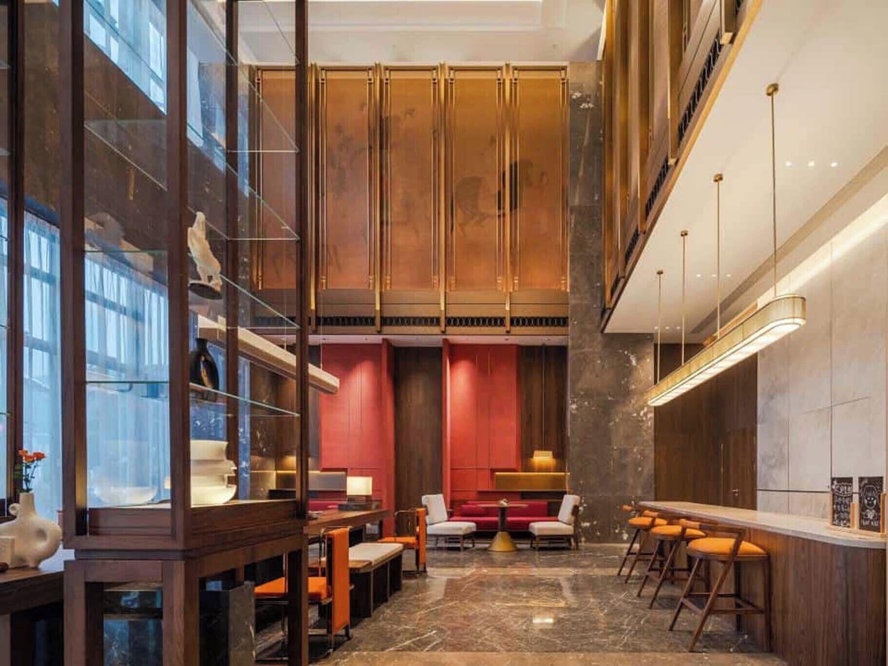 Un interior moderno con una zona de bar, asientos y vistas a través de un muro de cristal.