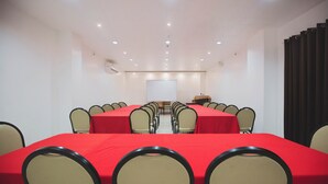 A conference room with a long table, multiple chairs, a projector screen, and a podium. - Hotel 801 Inc. (Cagayan de Oro)