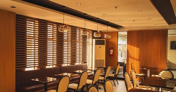 Un comedor moderno con listones de madera, luces colgantes y un extintor.