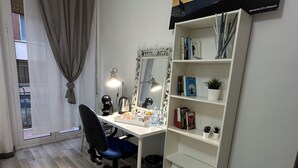 A room with a desk, chair, bookshelf, mirror, and a window with curtains. - Bright central apartment (foggia)