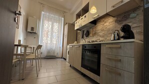 A modern kitchen with a dishwasher, oven, and a coffee maker on the counter. - Bright central apartment (foggia)