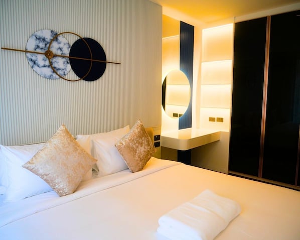 A hotel room with a bed, pillows, a bedside table, a mirror, and a wardrobe. - Above Element Bangtao Phuket by Arthouse Collection (Choeng Thale)