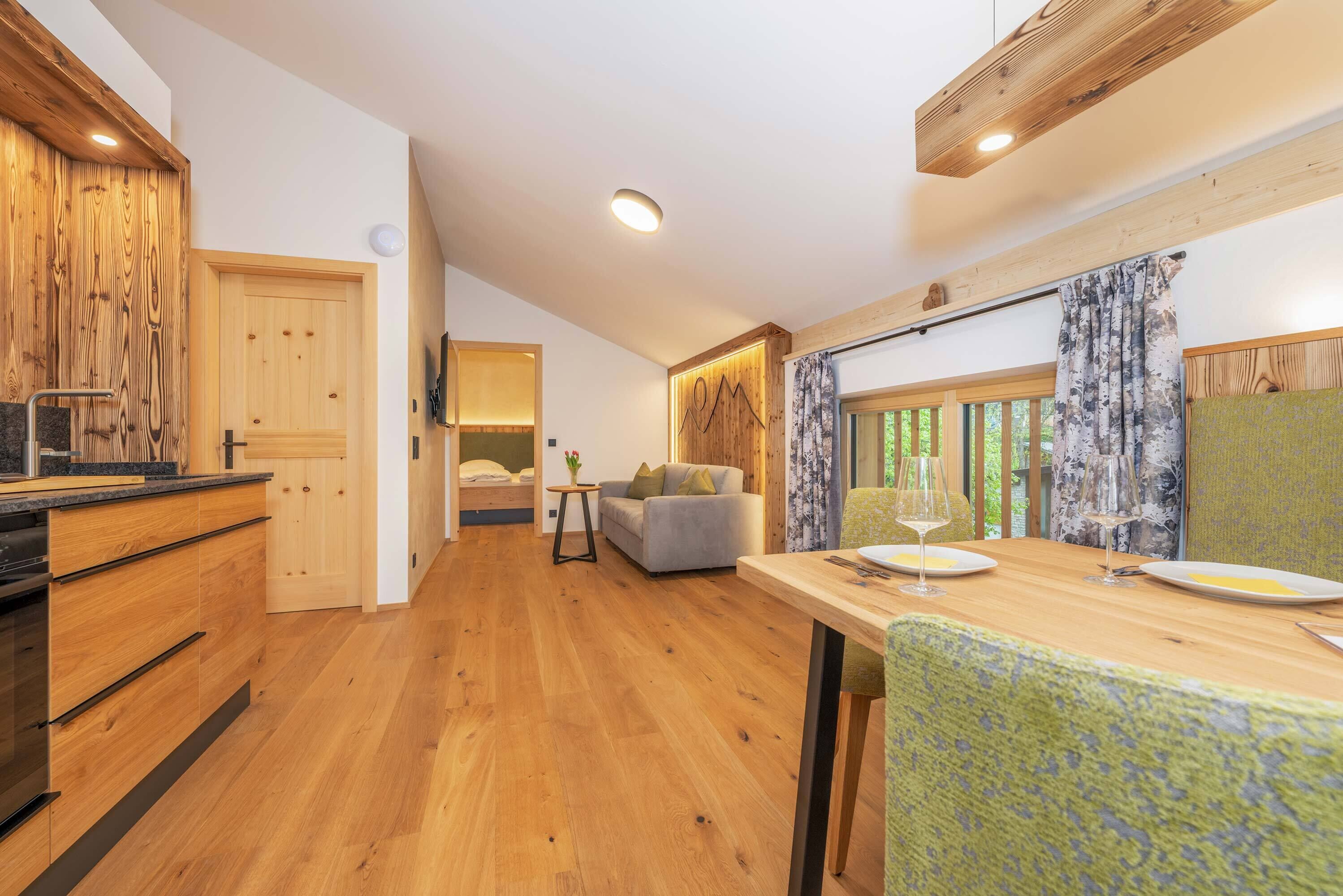 A modern kitchen with wooden cabinetry and a dining area with a table and chairs.
